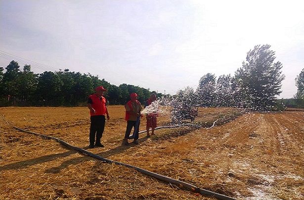 附件2：古饶镇平山社区抗旱先锋队党员在帮助缺少劳力户抗旱。.jpg